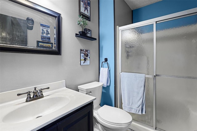 bathroom with a textured ceiling, toilet, walk in shower, and vanity