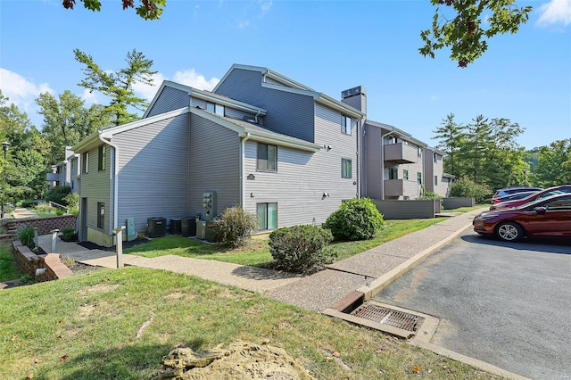 view of home's exterior with cooling unit and a yard