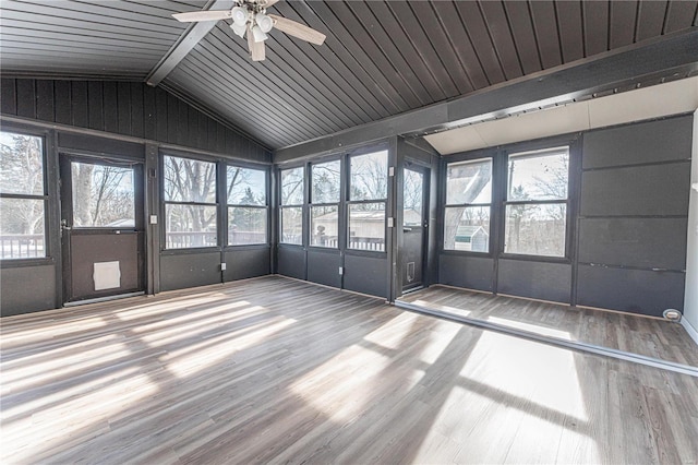 unfurnished sunroom featuring ceiling fan, lofted ceiling with beams, and a wealth of natural light