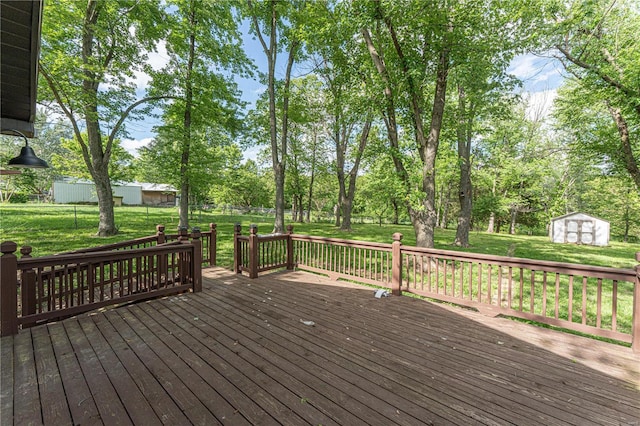 wooden terrace with a storage unit and a lawn