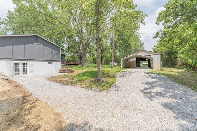 view of yard with a wooden deck and a carport