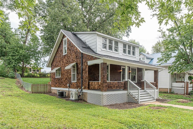 view of front of house with central AC, covered porch, and a front lawn