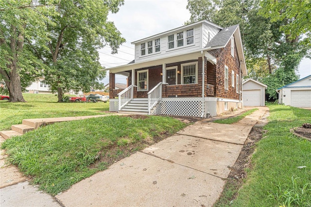 bungalow with a porch, a front lawn, a garage, and an outbuilding