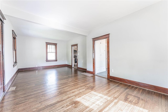 empty room with baseboards and wood finished floors