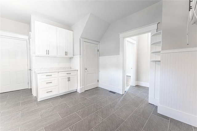 kitchen featuring white cabinetry and lofted ceiling