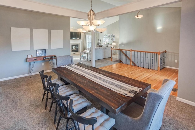 dining area featuring vaulted ceiling with beams and an inviting chandelier