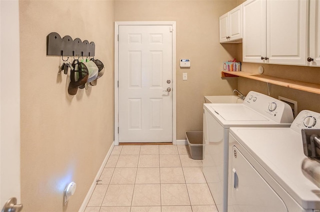 washroom with washer and clothes dryer, sink, light tile patterned floors, and cabinets