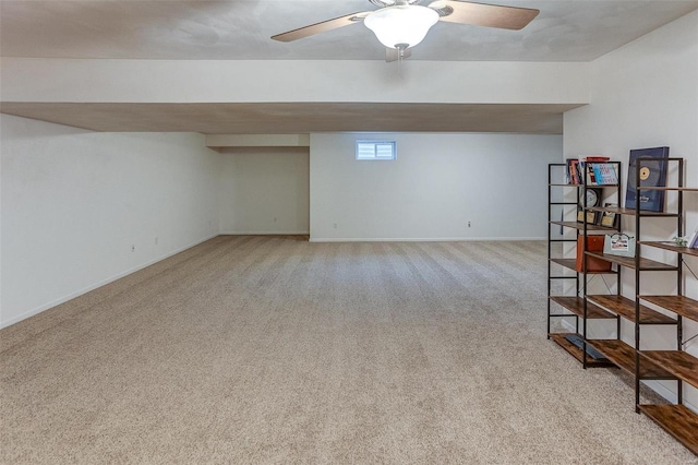 basement featuring light carpet and ceiling fan