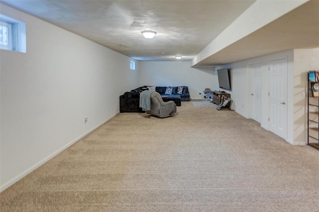 basement with a wealth of natural light and light carpet