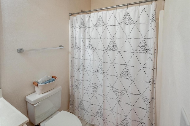 bathroom with curtained shower and toilet