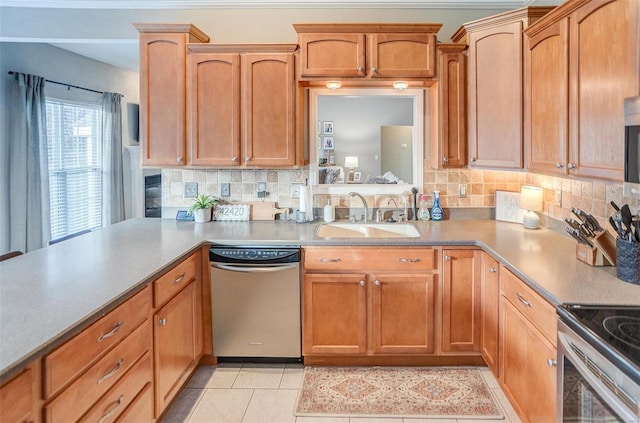 kitchen with decorative backsplash, appliances with stainless steel finishes, light tile patterned floors, and sink