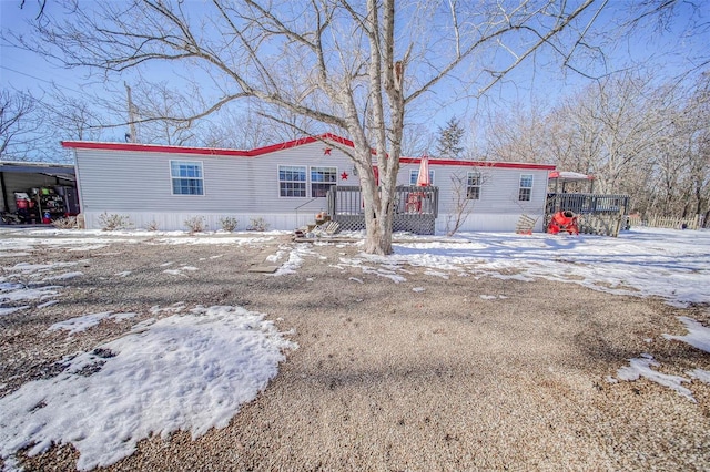 snow covered house featuring a deck