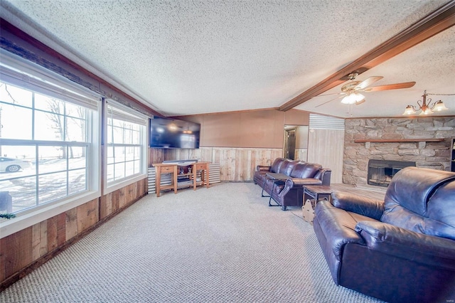 living room featuring ceiling fan, beam ceiling, wood walls, and a stone fireplace