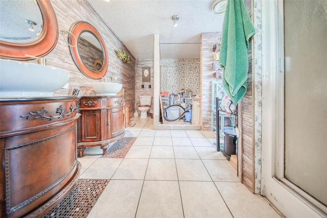 bathroom with toilet, vanity, tile patterned flooring, and a textured ceiling