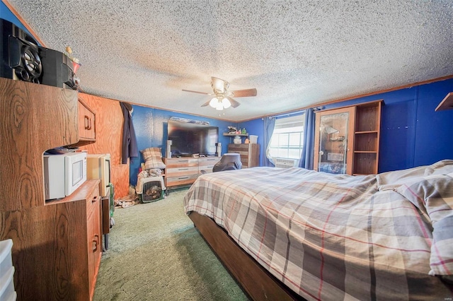 bedroom with ceiling fan, a textured ceiling, and carpet floors