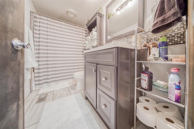 bathroom with a textured ceiling, toilet, a shower with curtain, and vanity