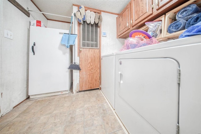 laundry room with cabinets, a textured ceiling, and separate washer and dryer