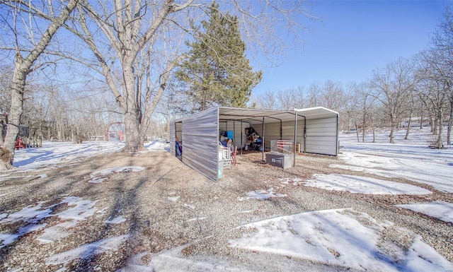 snow covered structure featuring a carport