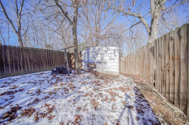 yard covered in snow with a storage shed