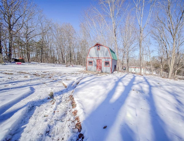 snowy yard featuring an outbuilding