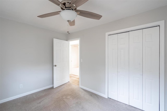 unfurnished bedroom featuring a closet, ceiling fan, and light colored carpet