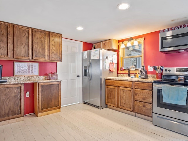 kitchen featuring sink, light hardwood / wood-style flooring, and appliances with stainless steel finishes