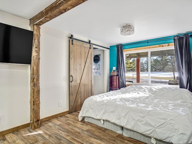 bedroom featuring wood-type flooring and a barn door