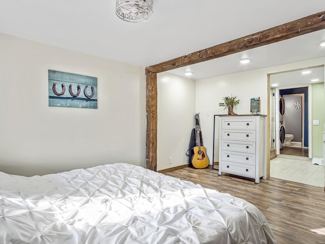 bedroom featuring ensuite bathroom and hardwood / wood-style floors