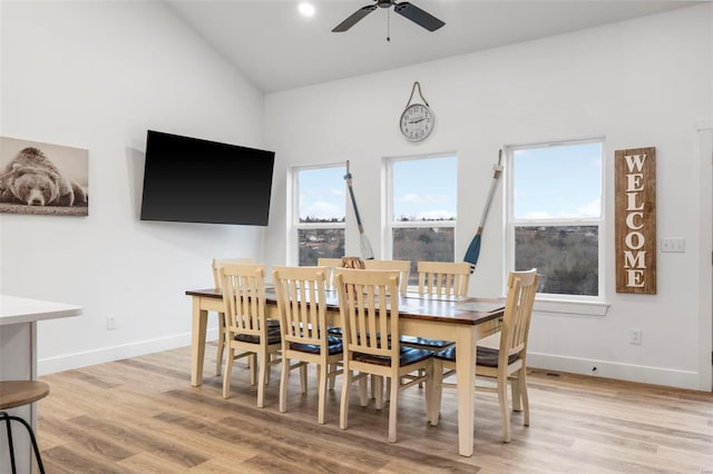 dining area with ceiling fan, light hardwood / wood-style flooring, and high vaulted ceiling