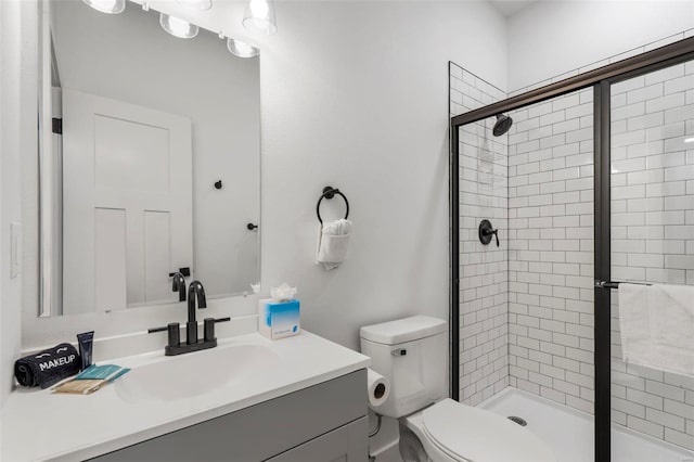 bathroom featuring toilet, vanity, and walk in shower