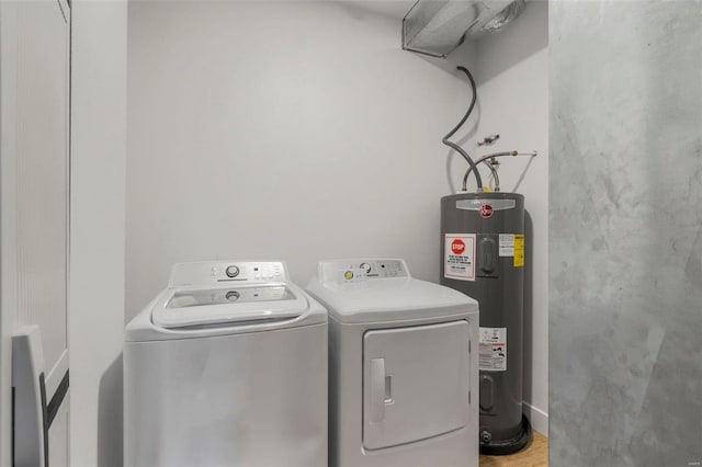 laundry room featuring electric water heater and separate washer and dryer