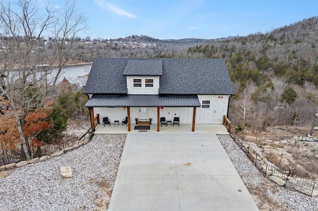 modern farmhouse style home featuring a mountain view, an outdoor hangout area, and a patio area