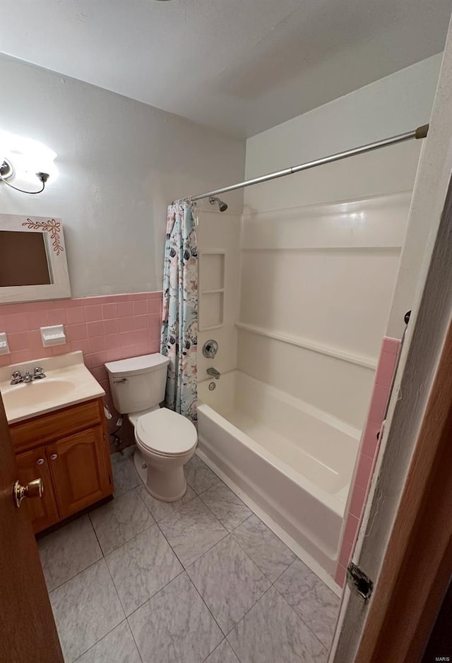 full bathroom with vanity, shower / bath combination with curtain, tile walls, and toilet