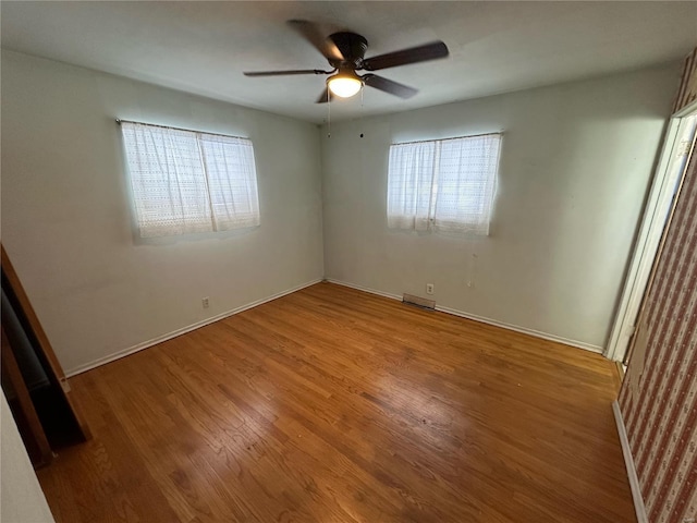 unfurnished room with ceiling fan and hardwood / wood-style floors