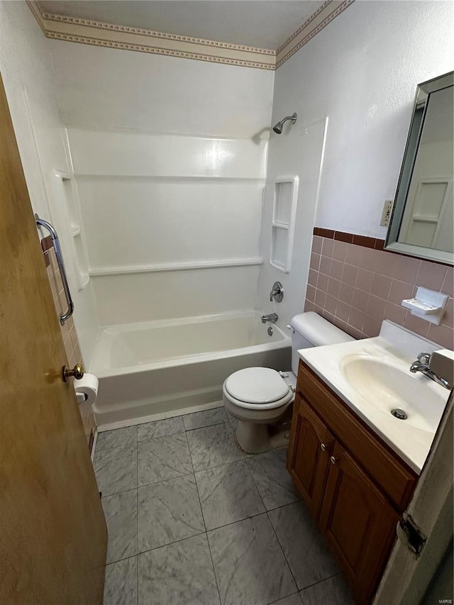 full bathroom featuring shower / bathing tub combination, vanity, toilet, and tile walls