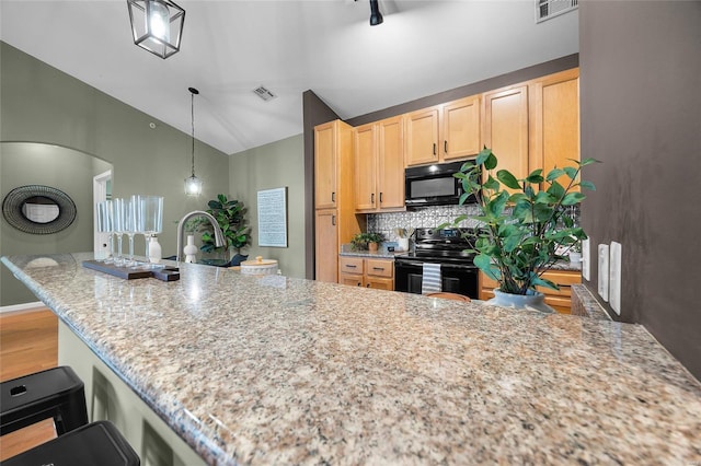 kitchen featuring pendant lighting, light brown cabinets, black appliances, decorative backsplash, and light stone countertops