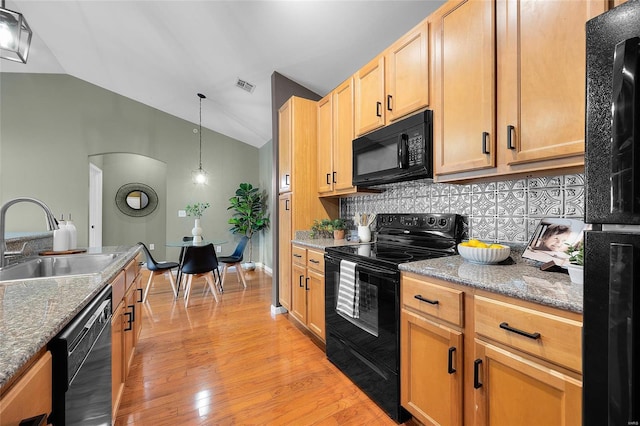 kitchen featuring light wood-type flooring, vaulted ceiling, sink, black appliances, and hanging light fixtures