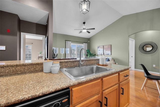 kitchen featuring lofted ceiling, sink, light hardwood / wood-style flooring, ceiling fan, and dishwashing machine