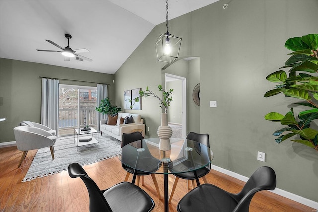 dining room with ceiling fan, light hardwood / wood-style floors, and lofted ceiling