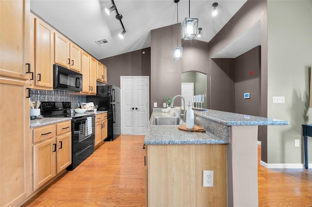 kitchen with black appliances, a center island with sink, sink, decorative backsplash, and light stone countertops