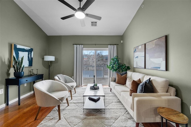 living room featuring ceiling fan, light hardwood / wood-style floors, and vaulted ceiling