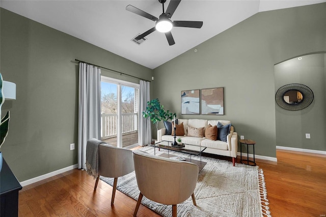 living room with hardwood / wood-style floors, vaulted ceiling, and ceiling fan