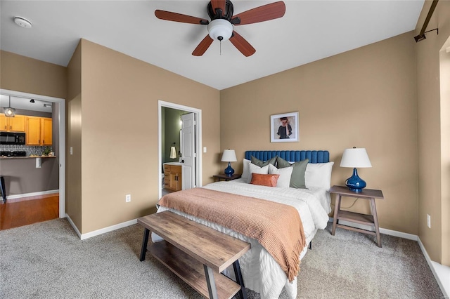 carpeted bedroom with connected bathroom and ceiling fan