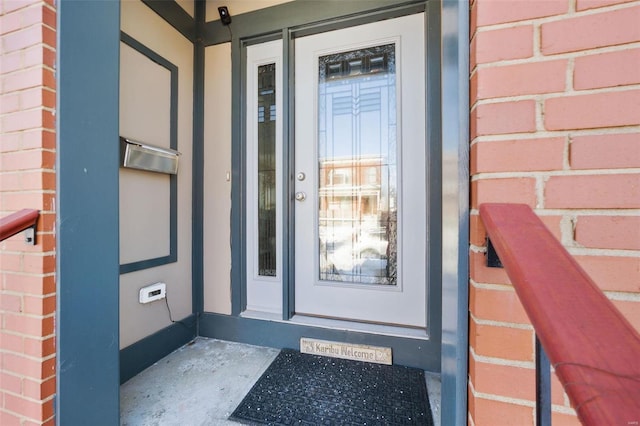 doorway to property featuring brick siding