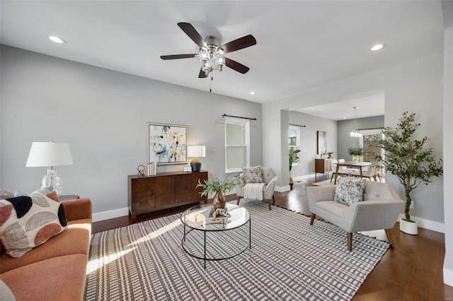 living room featuring ceiling fan and dark hardwood / wood-style floors