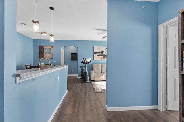 kitchen with hanging light fixtures, dark wood-type flooring, and ceiling fan