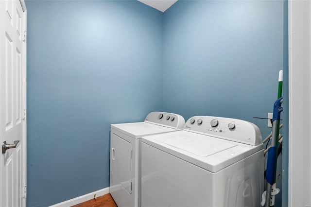 laundry room with separate washer and dryer and hardwood / wood-style floors