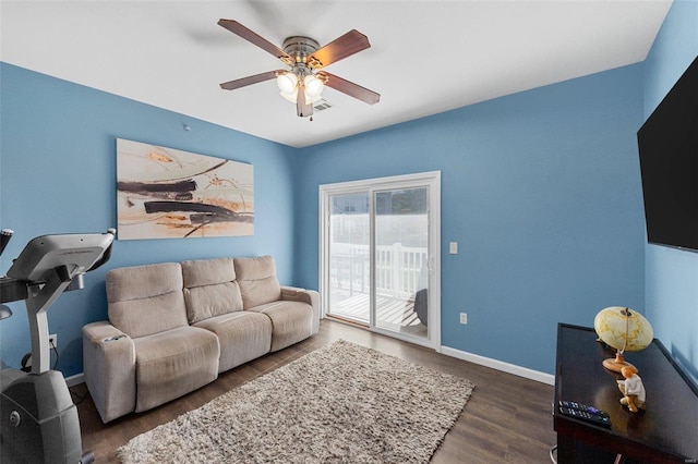 living room with dark hardwood / wood-style flooring and ceiling fan