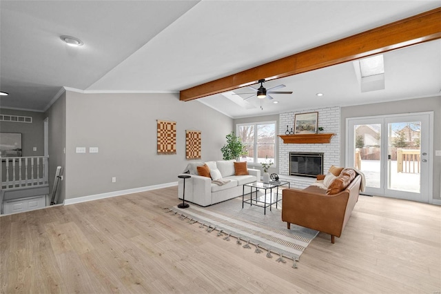 living room with plenty of natural light, ceiling fan, a fireplace, and light hardwood / wood-style flooring