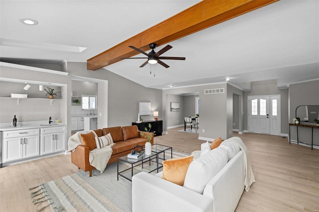 living room with vaulted ceiling with beams, ceiling fan, and light hardwood / wood-style floors